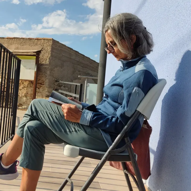 Mujer leyendo libro en el porche de la casa